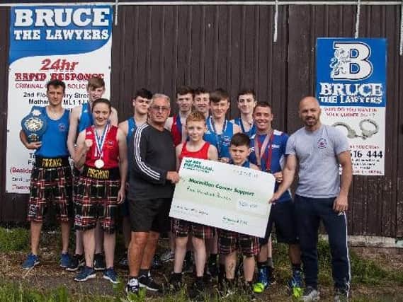 Forgewood Amateur Boxing Club head coach Bert McShane (holding cheque, front left) and the boxers whove been enjoying considerable success during 2018. They all helped to raise another 1600 for Macmillan Cancer Support this year, bringing the total they have donated in recent years to over 11,000. (Pics by Les Kingstone)
