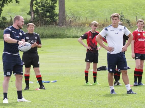 Stuart Hogg (holding ball) and Huw Jones (in white t-shirt) were happy to pass on their rugby tips to Biggar kids (Pics by Nigel Pacey)