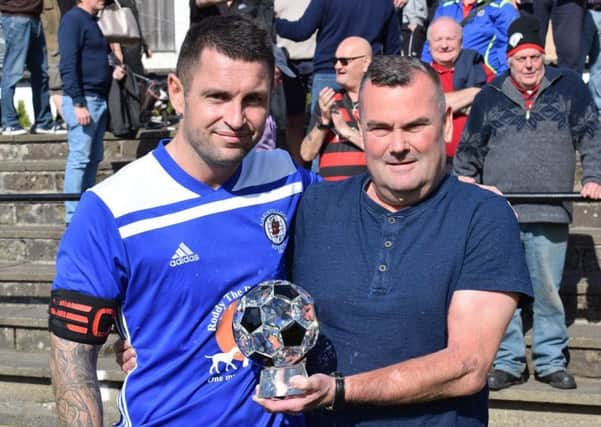 Scott Walker receives his man of the match award from sponsor Kenny Farmer after Rob Roy's win over Pollok