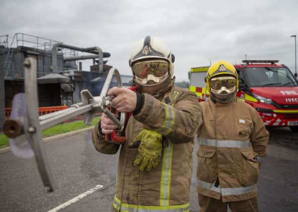 Firefighters from the Scottish Fire and Rescue Service, at their National Training Centre in Glasgow, demonstrate ultra high pressure lances, branded 'Coldcut Cobra', which will enable firefighters to blast a fire suppressant through the wall of a burning building. Pic: Jane Barlow/PA Wire