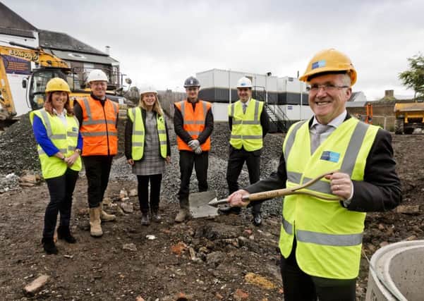 Daniel Lowe cuts the first sod on site watched by council officers and contractors.