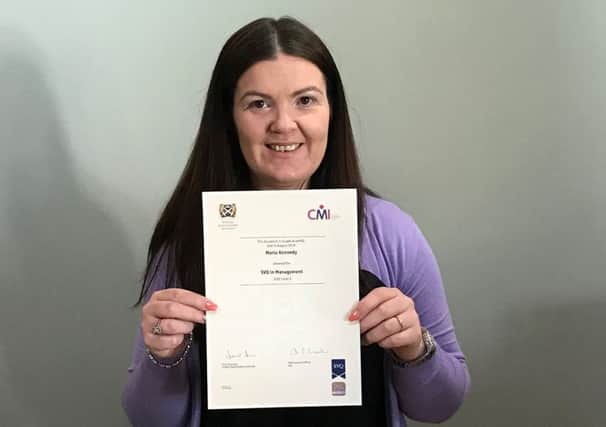 Maria Kennedy shows off her certificate after completing her course at Strathclyde University