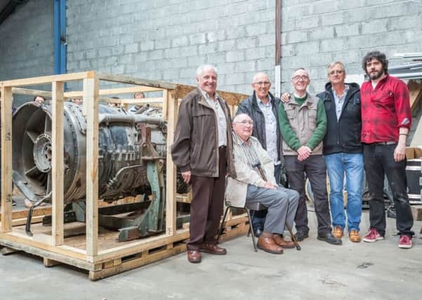 The former factory workers with one of the engines they refused to work on, effectively grounding the Chilean fighter jets.