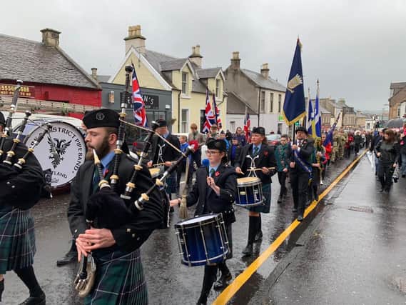Defying the eather, Lanark Pipe Band leads the large parade to the Memorial Hall on Sunday