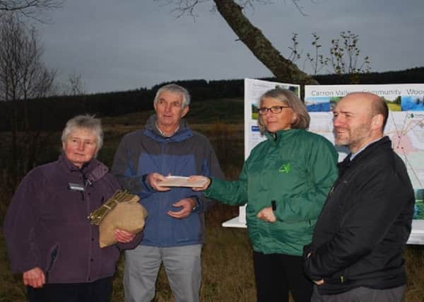 Carol McGinnes from Forest Enterprise Scotland and Neil Ritch from Big Lottery hand over title for the Carron Valley Community Woodland and to Peter Hayward of the community council and Margaret Porter of Valley Renewables Group