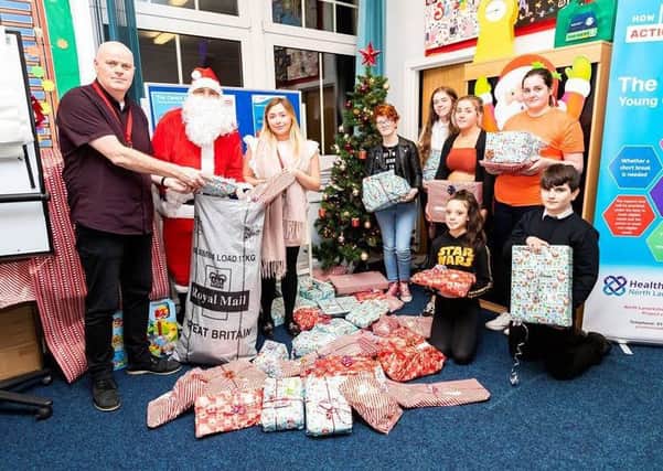 Royal Mails David Goldie helps Father Christmas deliver the Secret Santa presents to young carers in North Lanarkshire