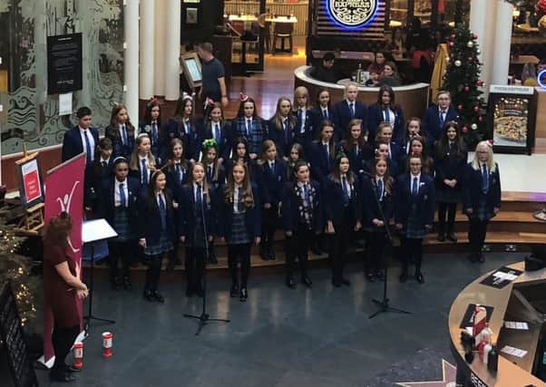 Pupils from Dalziel High School sing Christmas carols for shoppers at Princes Square in Glasgow.