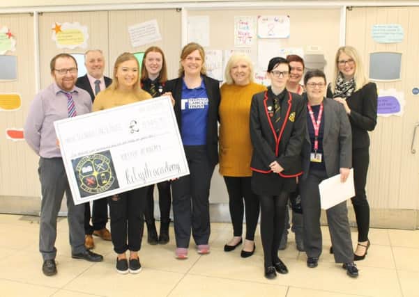 Staff and pupils from Kilsyth Academy present the cheque to Emma Vickerstaff of Teenage Cancer Trust (centre left), joined by Nicole Lowther (second left) and her mum Lorraine (centre right)