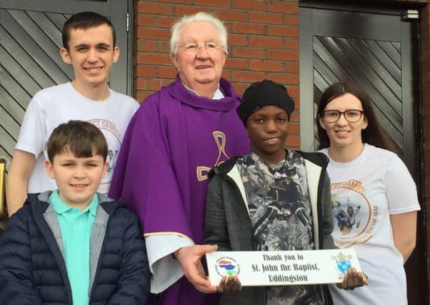 Father Dominic Towey and wee Alieu with the plaque that will be put up at St Johns School for the Deaf along with one for all of the other parishes which have provided support