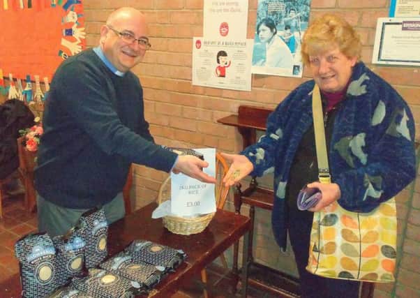 Rev. Scott Blythe selling a bag of rice to Mrs Sheila Wurthman at Stamperland Church