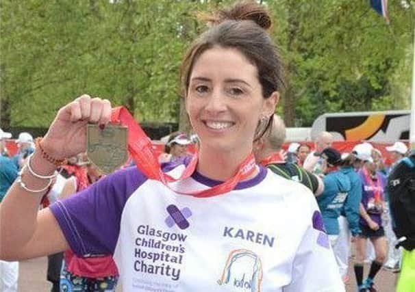 Karen Barnstaple shows off her medal after completing the London marathon