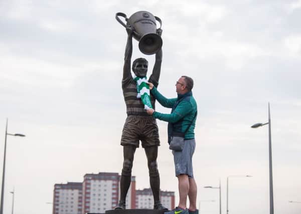 A Celtic fan pays tribute at the statue of Billy McNeill which was erected outside Parkhead