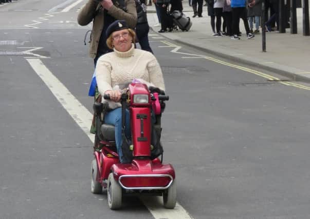 Denise Walker rides along the route of the protest on her mobility scooter. Pic: Stan Kaye