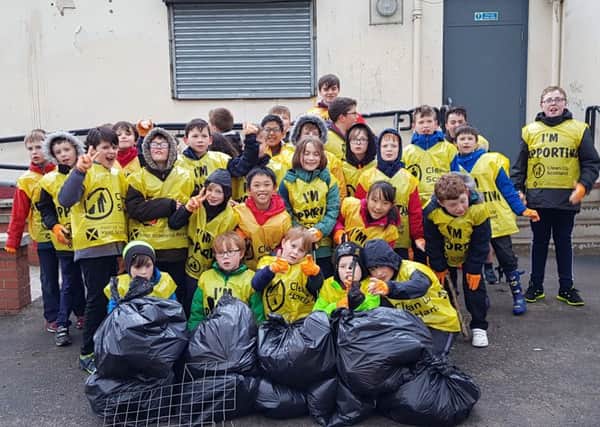 The community-conscious Cub Scouts with the rubbish they removed from the playing fields.