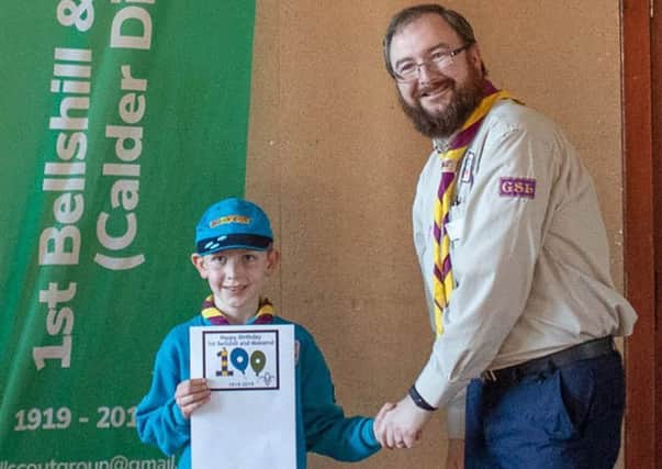 1st Bellshill and Mossends Group Scout Leader Mark Lunny presents Andrew Megan with a copy of his winning badge design