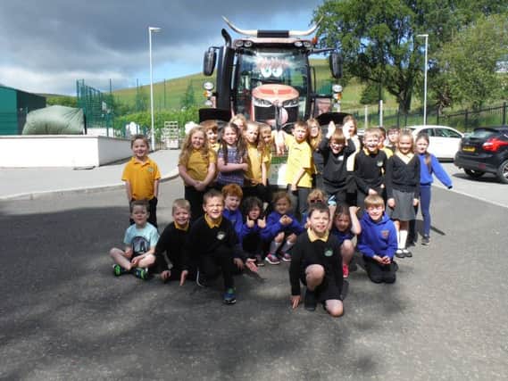 The pupils are pictured with RHET chairman George Lawrie and his tractor, in which he is undertaking a 600-mile trip.