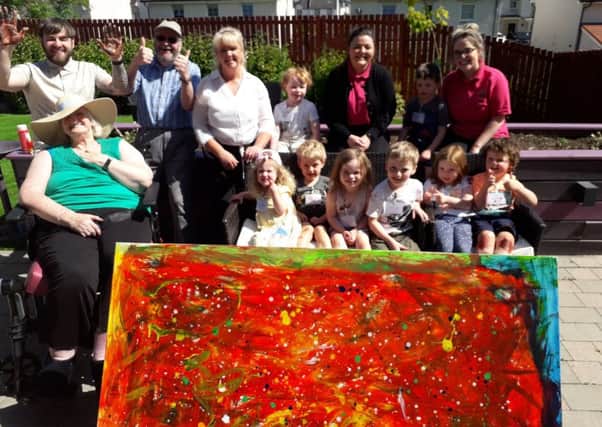 Residents of Newton House Care Home, members of the community and children from Kirktonholme Mearnswood Nursery with their masterpiece.