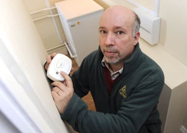 Malcolm Farrow, from OFTEC, checks his carbon monoxide alarm.